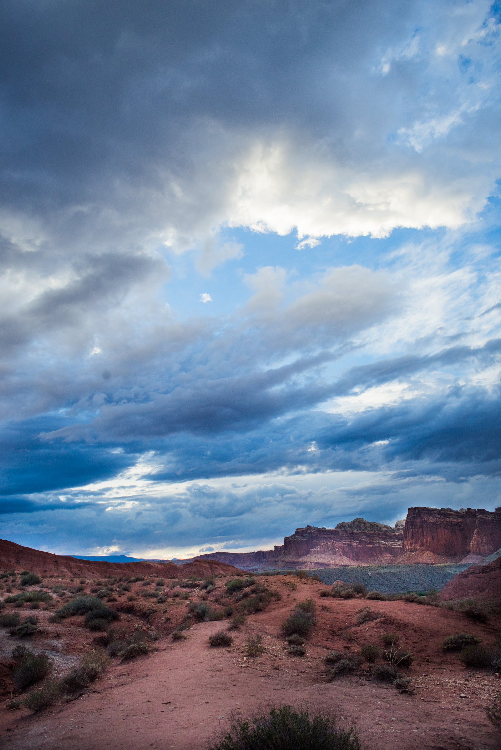 Dramatic red rock landscape with blue stormy skies above.