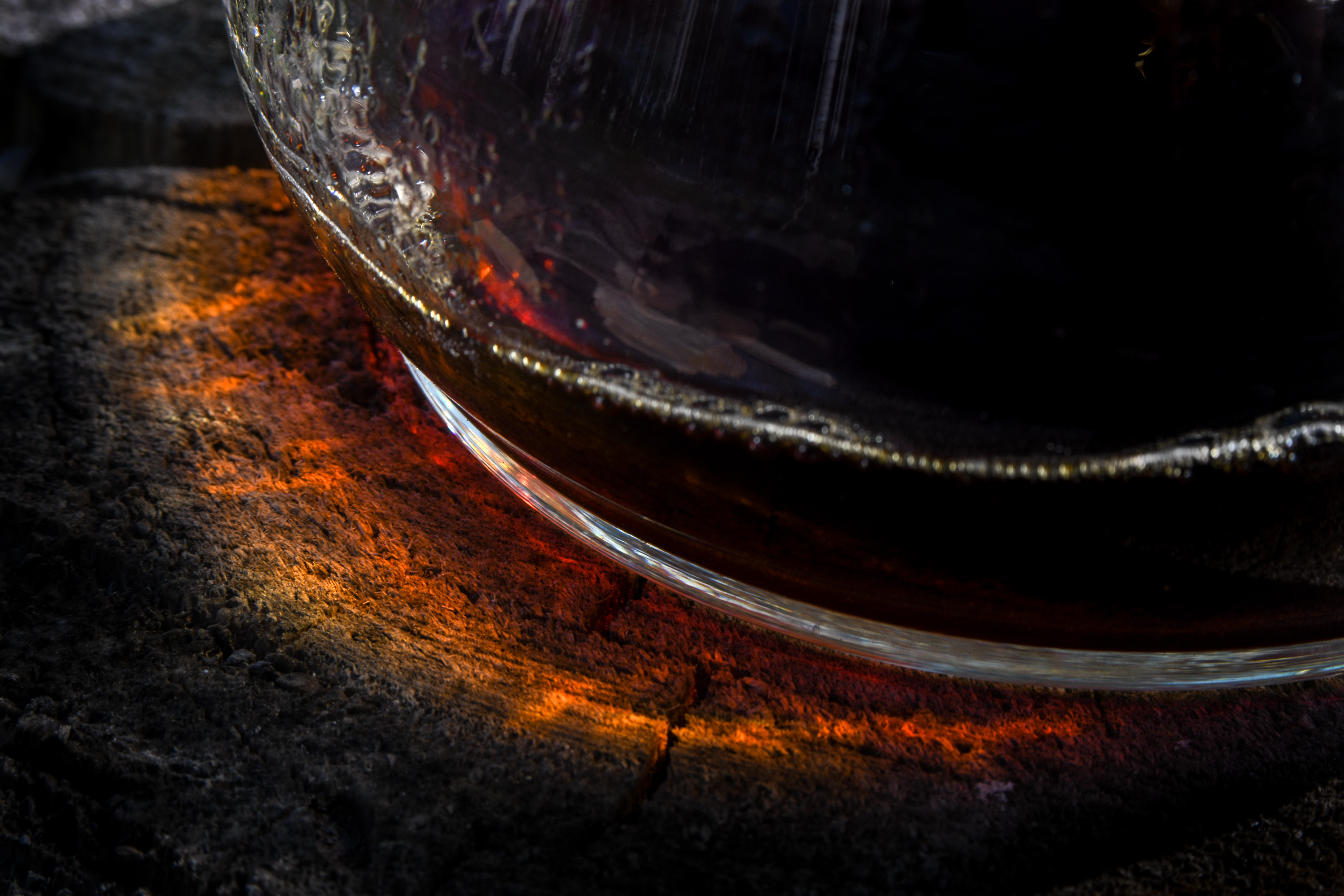 Halo of light through a glass coffee keraff onto a stump.